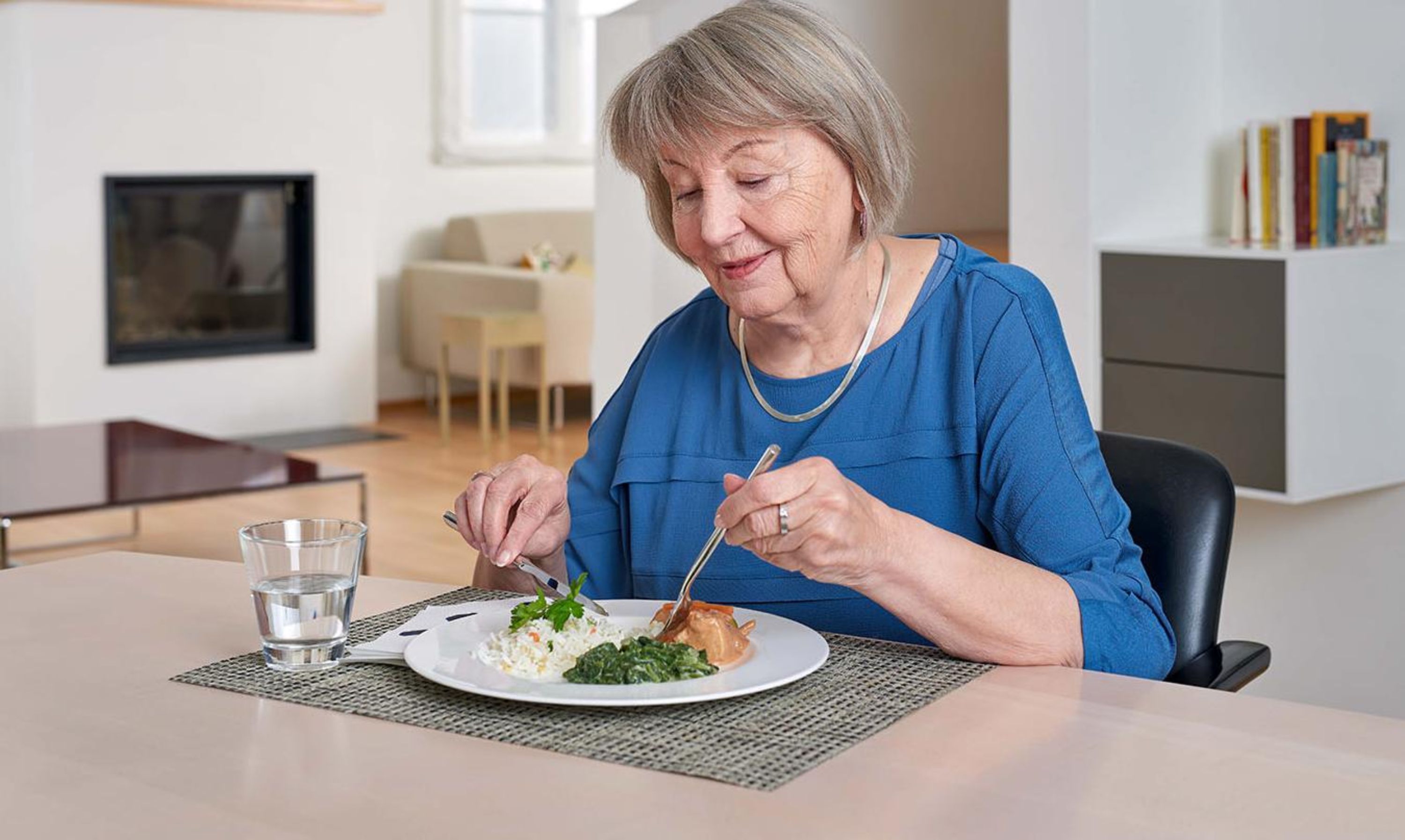 Eine Seniorin geniesst ihr Mittagessen vom Mahlzeitendienst von Pro Senectute.