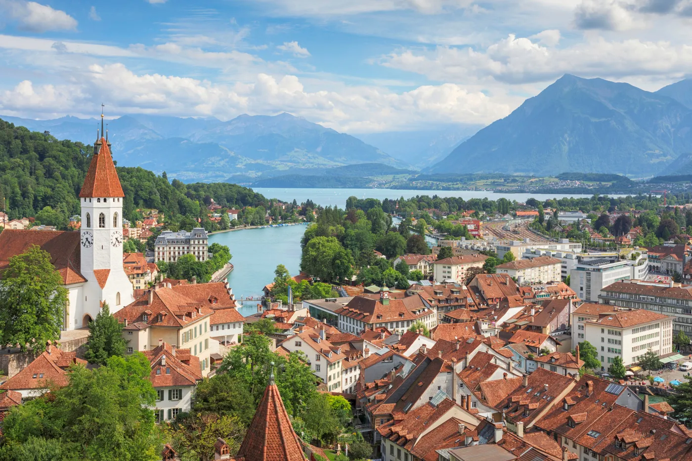 Bild mit Stadtkirche von Thun im Vordergrund. Im Hintergrund der Thunersee und der Niesen.