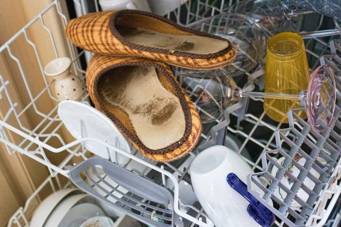 Photo en plus des verres et des tasses, il y a une paire de pantoufles dans le lave-vaisselle.